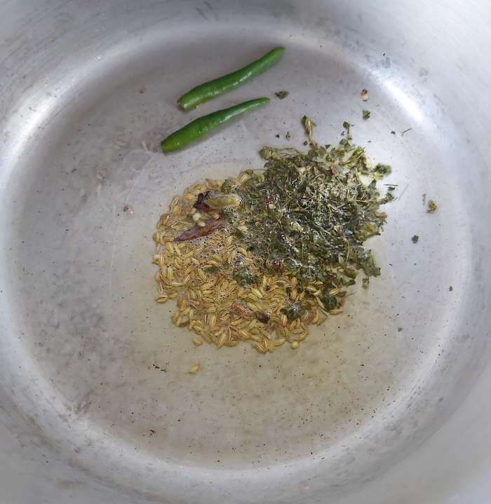 Add 1 teaspoon of fennel seeds, 1-2 teaspoons of kasuri methi or dry fenugreek leaves and 1-2 slit green chilies. Fry for a minute.