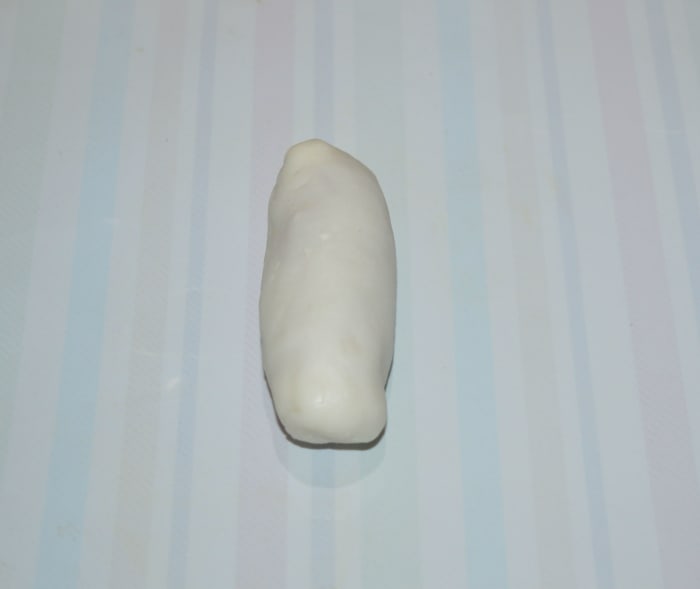 Join the open edges, so that the dough evenly covers the stuffing on all sides. Now you get a raw oblong dessert. Similarly, prepare all the raw dessert dumplings.