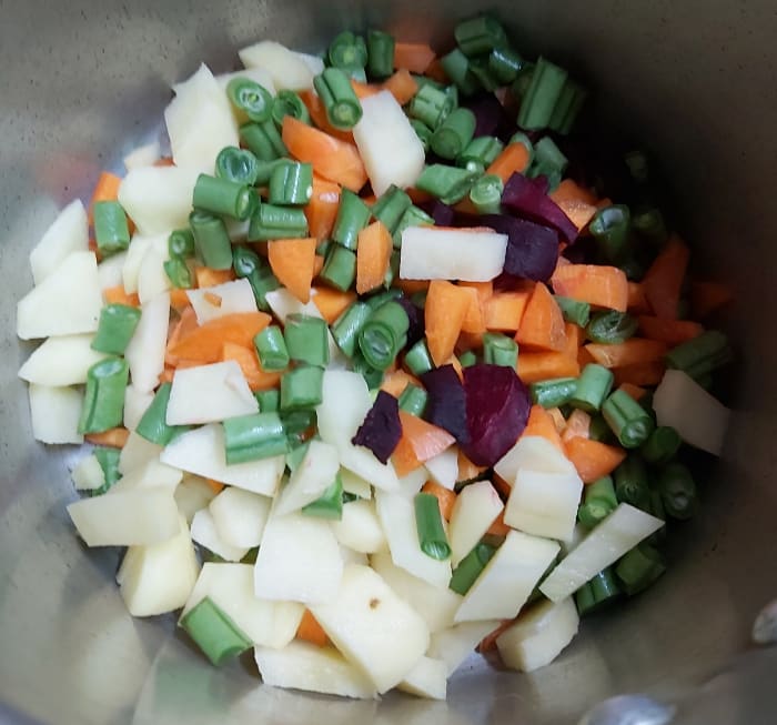 Add carrots, beans, potatoes, beetroot to a pressure cooker (if you are using fresh or dry peas add that too. No need to add frozen peas as it can be easily cooked).