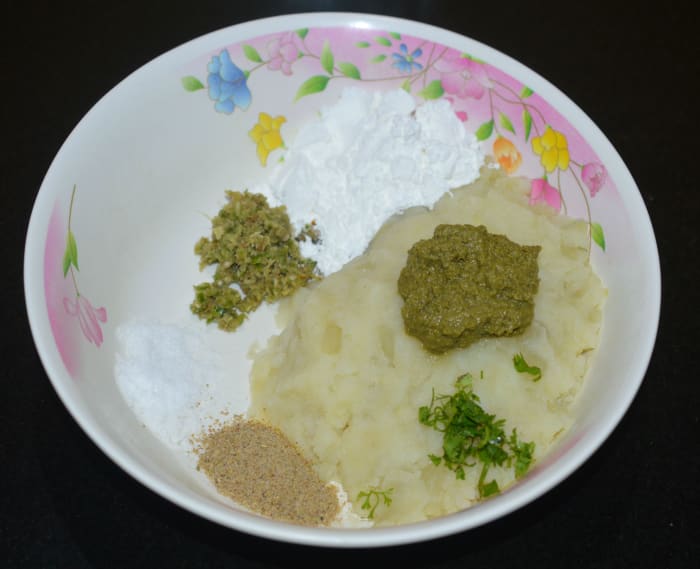 Step one: Make the patties. Add mashed potato, cornflour, chat masala powder, green chutney, ginger-green chili paste, chopped coriander leaves and salt to a mixing bowl.