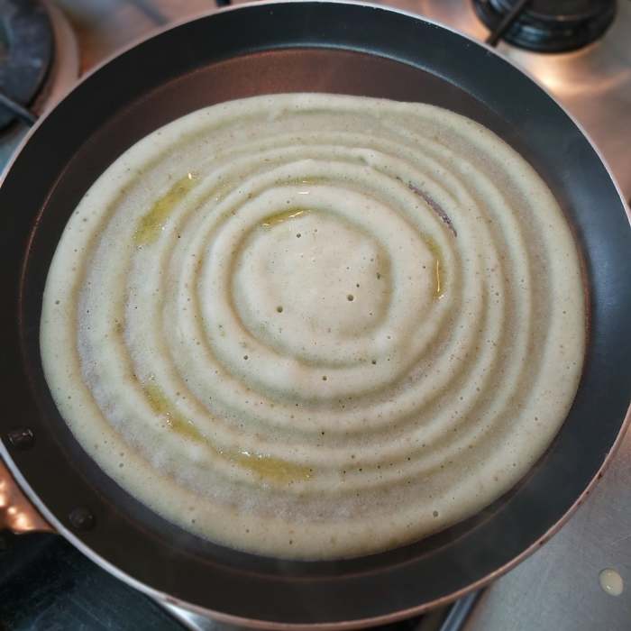 Smear a few drops of ghee on the dosa. Cover and cook on medium to low heat for about 1 minute or till it has cooked properly.
