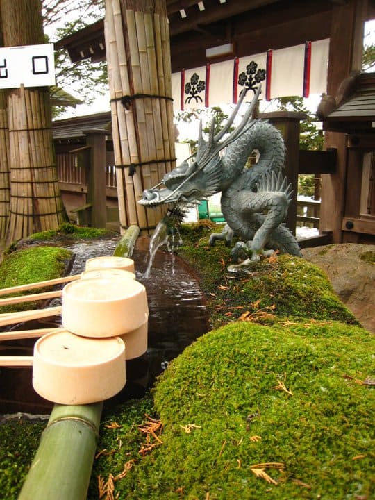 A close up of the ladles and water, both important tools to cleanse yourself before entering a shrine.