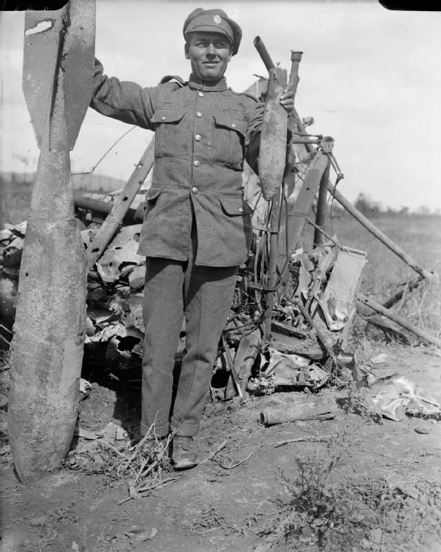 WW1: British serviceman with a large and smaller bomb from the wreckage of a twin-engined Gotha bomber aircraft at Ravelsberg Camp.