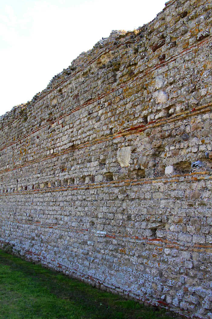 The characteristically imposing Roman wall on the north side of Rutupiae, built of flint stone, concrete and tiles, c 273 AD and still largely intact today