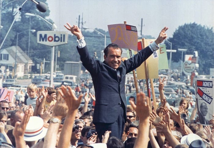 Richard Nixon gives his trademark "victory" sign while in Paoli, PA (Western Philadelphia Suburbs/Mainline) during his successful campaign to become President of the United States. 1968.