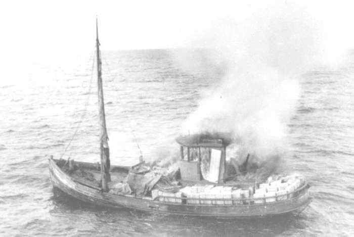The crew of this boat has set their vessel on fire to destroy the evidence they are smuggling contraband liquor.