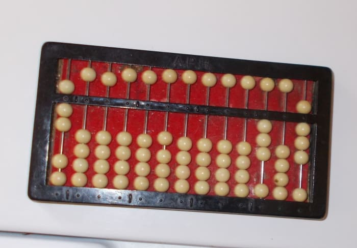 Division problems are placed on the abacus in a different way. The abacus in this photo reads: 308 divided by 7.