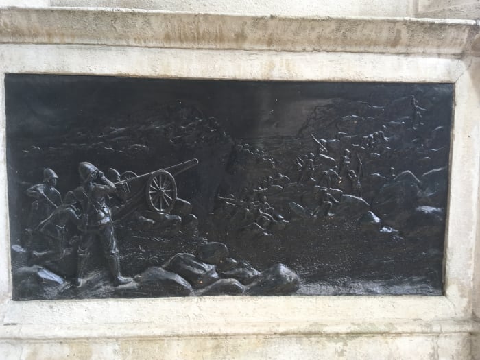 Bronze relief depictiong the Royal Marines and Naval Brigade employing their guns in action in South Africa - details from the Royal Marines Memorial
