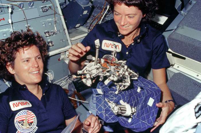 Kathryn Sullivan (left) and Sally Ride playing with sleep restraint on board Challenger mission STS-41G