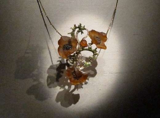 A delicate poppy necklace made in the early 1900s by René Lalique. It is gold, diamonds, enamel and glass.