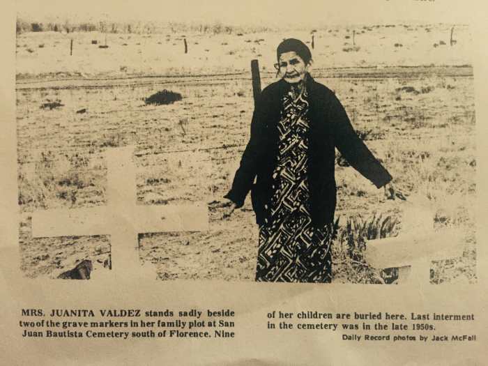 "Mrs. Juanita Valdez stands sadly beside two of the grave markers in her family plot at San Juan Bautista Cemetery south of Florence. Nine of her children are buried here. Lat internment in the cemetery was in the late 1950s."