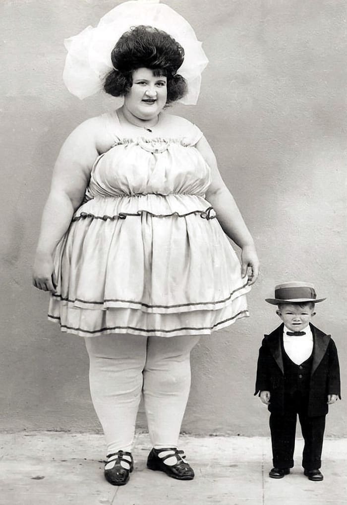 Clarence Howerton grew to be two feet four inches tall. In this image next to a lady billed as the world's biggest woman he is only nine years old.
