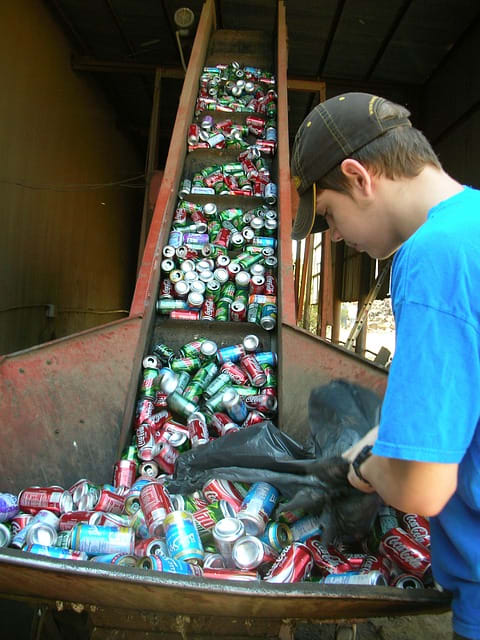 Organizing cans at a waste management center. Pretty much all metal can be melted down and re-used. Some types of metal have a scrap value too, and can actually make you some money.