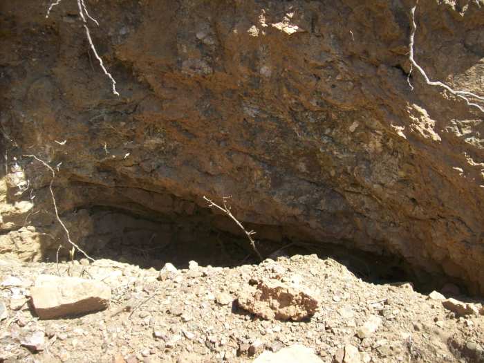 A cutout - this could be natural erosion, but I think from the look of the rock that someone was digging out a quartz stringer.