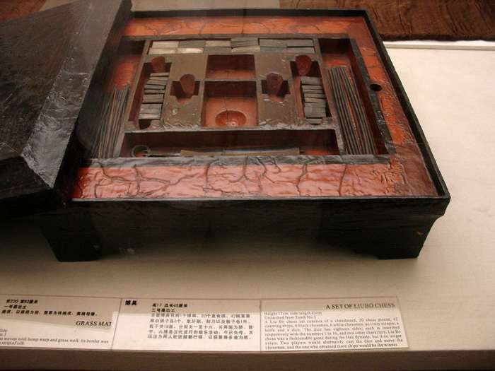 A lacquered Chinese liubo board game set excavated from Tomb No. 3 of Mawangdui, Changsha, Hunan province, China, c. 2nd century BCE. The set featured a lacquered game box, lacquered game board, 12 cuboid ivory pieces, 20 ivory game pieces, 30 rod-sh