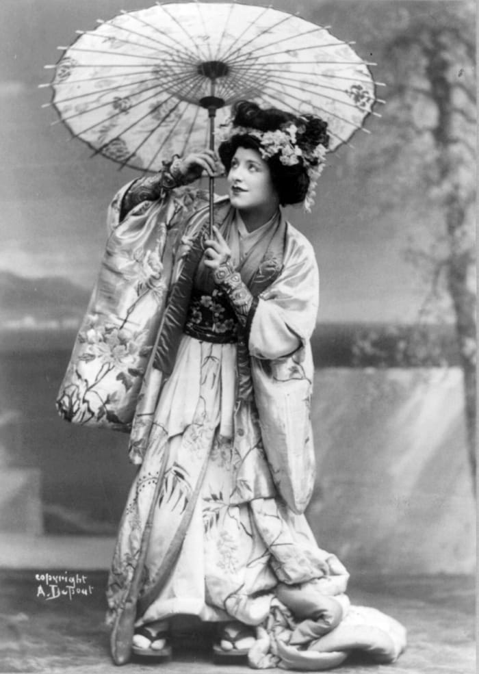 Geraldine Farrar in the role of Madame Butterfly, holding a parasol, in a production from 1908.