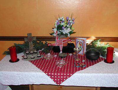 An altar for Imbolc. Brigith's cross is center with a picture of the saint to the right and the Christian cross on the left