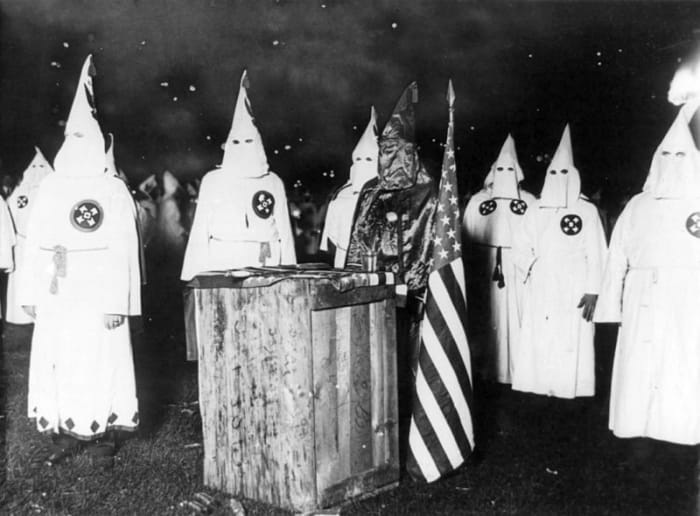 A Ku Klux Klan night rally in Chicago, around 1920. Threats from the KKK compelled Malcolm X's family to move in 1926 to Milwaukee, Wisconsin, and shortly thereafter to Lansing, Michigan.