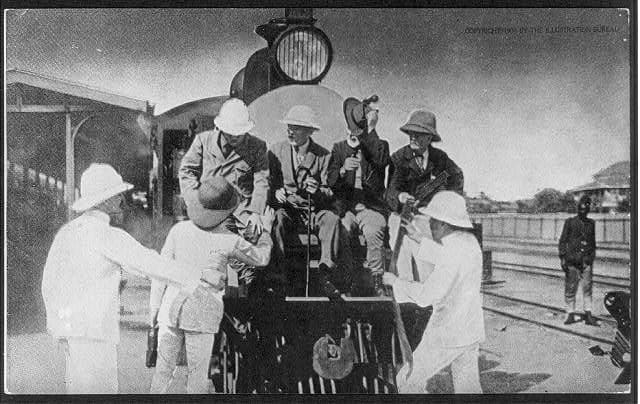 Theodore Roosevelt (left on the buffer beam) poses with the pith-helmeted colonial administrators on the Uganda Railway.