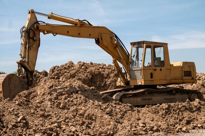 An excavator (digger) has several connected levers on its boom. Hydraulic cylinders produce the force required to move the levers.