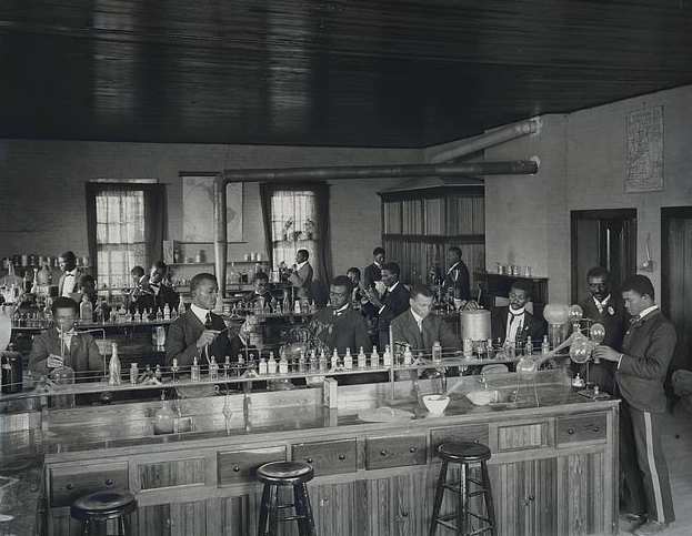 Chemistry laboratory at Tuskegee Institute, circa 1902. Carver stands second from right, facing front.