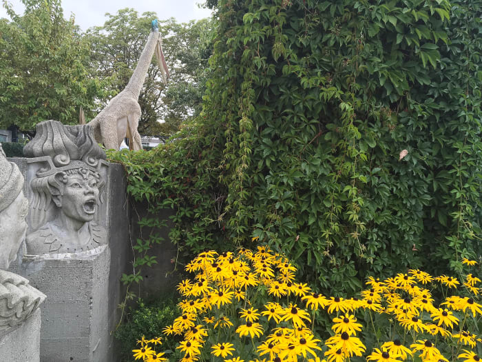 An unusual combination: sculptures of characters from Italian operas, black-eyed Susan flowers, Boston ivy leaves, and a Quetzalcoatlus model in the background