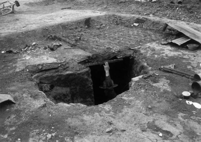 A man inspects an underground shelter at the UMW camp for coal miners on strike against CF&I in Forbes, Las Animas County, Colorado, in which women and children died during a fire set by the Colorado National Guard.
