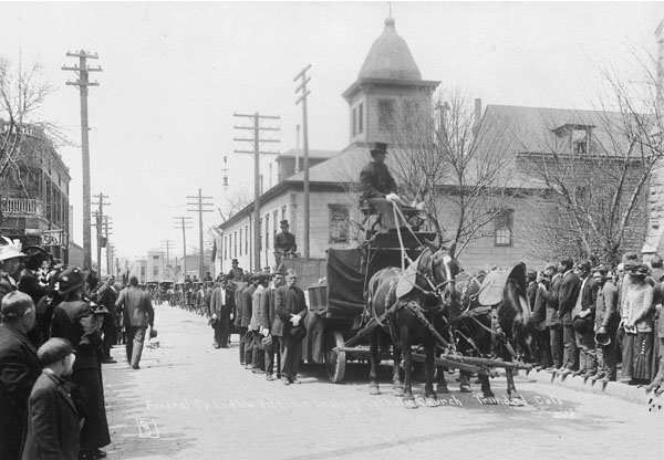 "A funeral for twenty one people who died when state militia attacked and burned a tent colony set up by striking coal miners."
