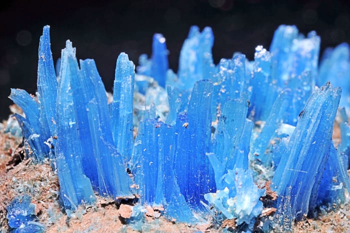 Crystals of chalcanthite (blue) and limonite (brown) minerals; chalcanthite is hydrated copper sulphate while limonite is a mixture of hydrated iron oxides