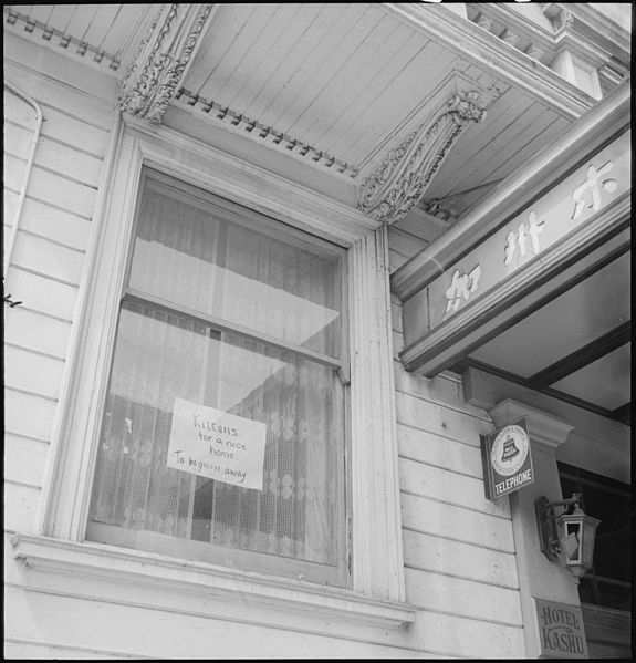 WW2: A Japanese family prepares for evacuation. The sign reads: "Kittens for a nice home. To be given away."