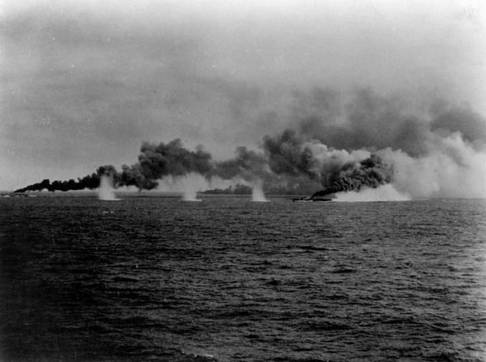WW2: U.S. destroyers and destroyer escorts laying a smoke screen during the Battle of Samar, 25 October 1944. Note the splashes from Japanese shells.