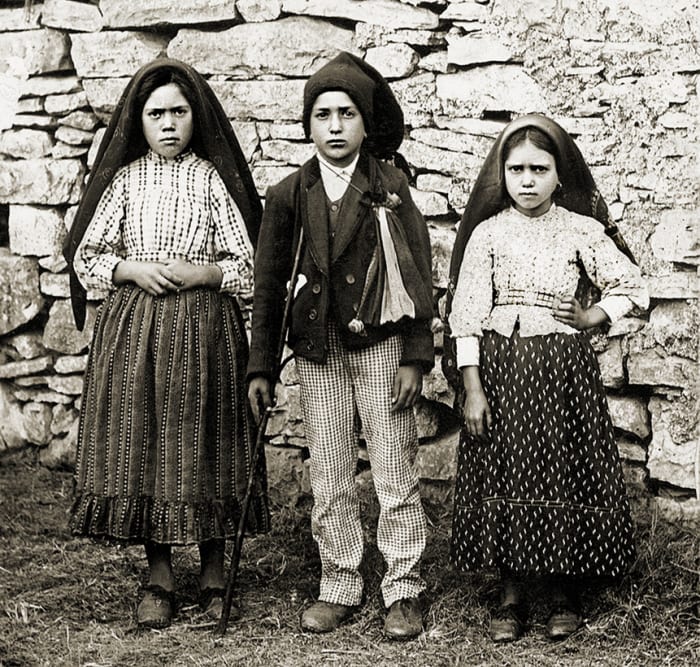 Lucia de Santos is on the left with her cousins, Francisco and Jacinta Marto.