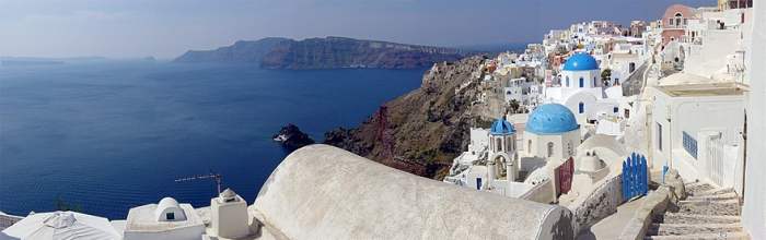 The whitewashed architecture of the Greek Islands attracts visitors from all over the world. Less noticeable is the great body of water on the left, which is actually an ancient caldera