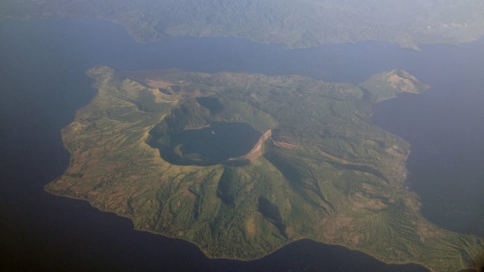 This aerial photo clearly depicts the water-filled caldera from an ancient supervolcano eruption. Today, the body of water is known as Lake Taal.