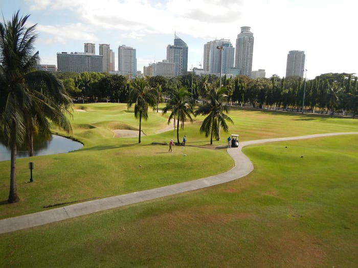 Intramuros golfclub with city skyline in background. About 2 million live in Manila today.