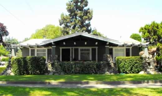 The effect of the river rock stone coming out of the ground to support a low house with jutting beam trim is classic arts and crafts on this California bungalow.