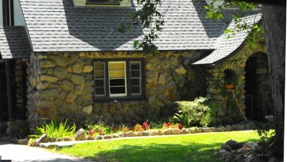 Large boulders are used here in this home in La Verne. Notice the curved entrances and window openings. The vertical accent over the windows is a common treatment. This home reflects a traditional east coast storybook style home.