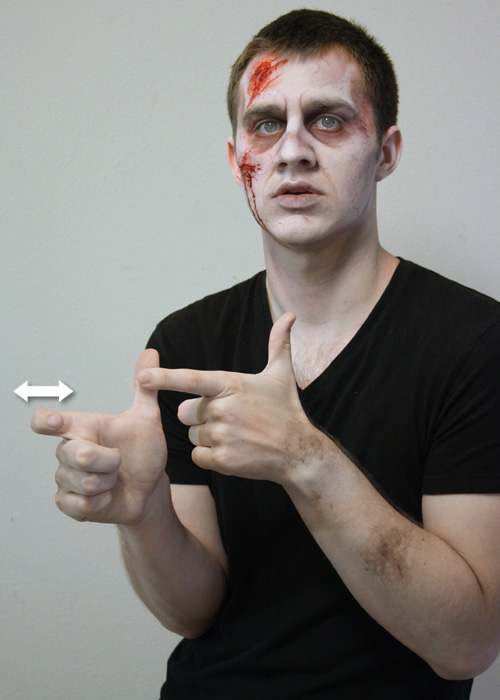 Version 1: The left hand is held thumb up and the index finger hooked on the thumb of the right hand. The right index finger then bends and extends quickly.
