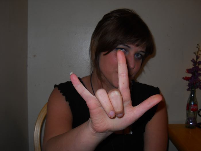 "I love you": Hold up one hand with your thumb, index finger, and pinkie finger splayed. (In contrast, devil horns do not involve the thumb.)