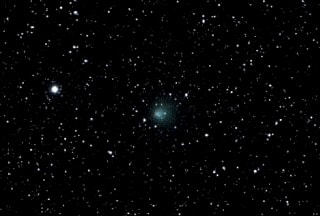 Encke's Comet. Occasionally a comet will become visible to the naked eye. Usually it will appear as a light smudge such as the comet in the centre of this image.
