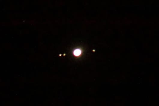 Jupiter and three of its moons. The image is not clear, but deliberately so, as it shows what you are likely to see of Jupiter's moons if you use simple binoculars. (In my binoculars, the planet and moons appear a bit sharper than this, but fainter