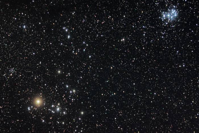 The Hyades and Pleiades in the constellation Taurus. The bright orange star is Aldebaran. Immediately right of Aldebaran is the cluster of stars which make up the Hyades. In the top right is the more conspicuous Pleiades