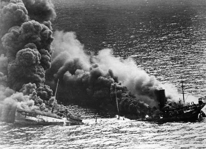 WW2: Allied tanker torpedoed in Atlantic Ocean by German submarine. Ship crumbling amidship under heat of fire, settles toward bottom of ocean. March 26, 1942.