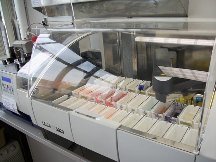 a robotic arm moves slides through the various reagents on this automatic tissue stainer
