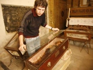 A caretaker at the catacombs overlays a second sheet of glass over Rosalia's coffin for added protection.