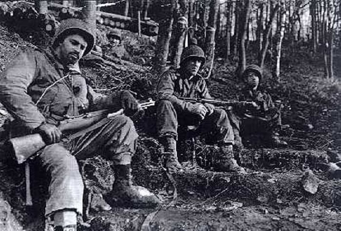 One look says it all: Grim GIs from the 8th Infantry Regiment of the 4th ID taking a break in the Huertgen. They appear to be wearing overshoes, which helped a lot in keeping their feet warm and dry. Those would become in short supply by winter.