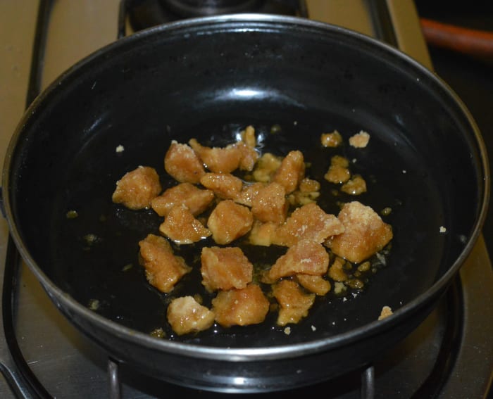 Step four: Add powdered jaggery to a deep-bottomed pan and heat it. Add 3 teaspoons of water. Stir the mixture. After some time, the jaggery melts completely. Let the mixture boil for 2-3 minutes.