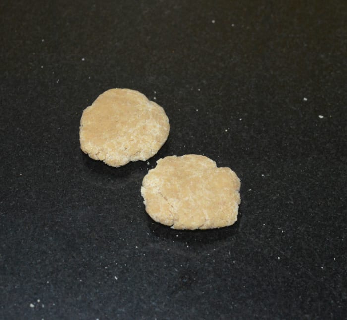 Adding a very small amount of water, make a stiff, lump-free dough. Divide the dough into many lemon-sized portions. Shape each of them into patties.