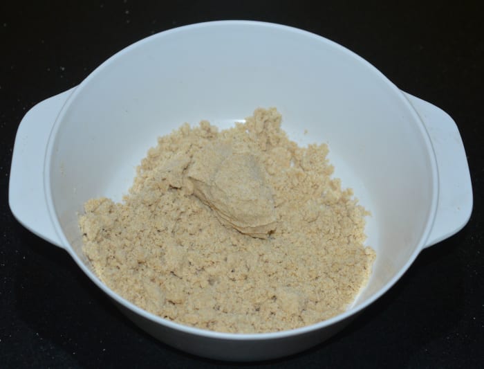 The mixture should be such that if you hold some mixture in your fist and press, it should make a shape. If you can't shape it, add a little more hot ghee and mix well.
