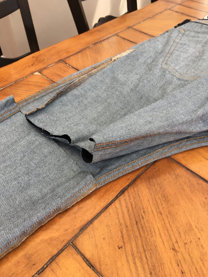 Fold the jeans in half to make sure the length and angle of the cut are the same on both legs.